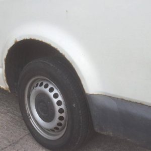 white camper van with rust in wheel arch